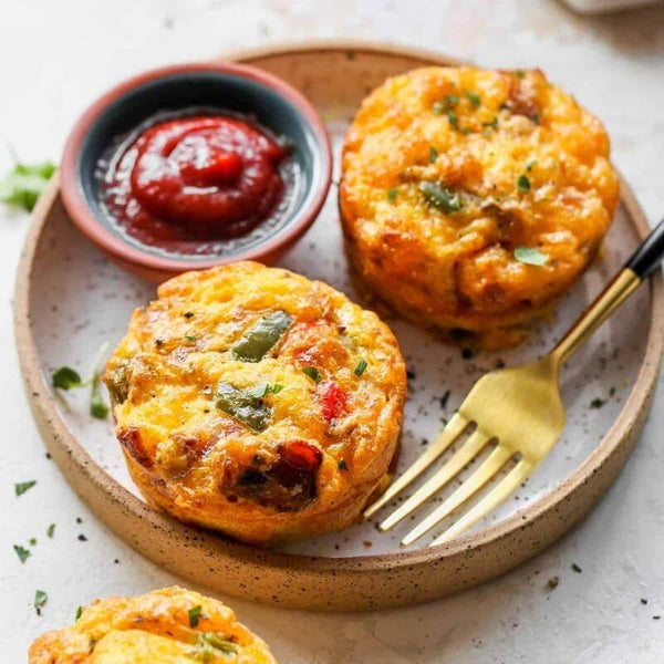 High-protein steak and egg muffins served on a plate with a side of dipping sauce, a perfect healthy breakfast meal prep option.